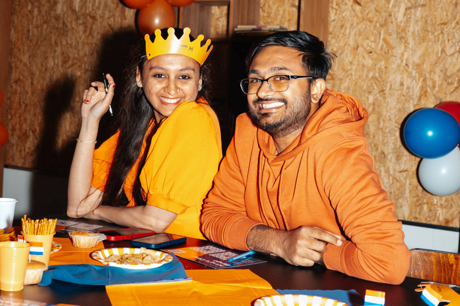 People smiling in camera with orange clothes on